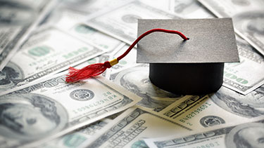 Graduation mortarboard on top of printed money