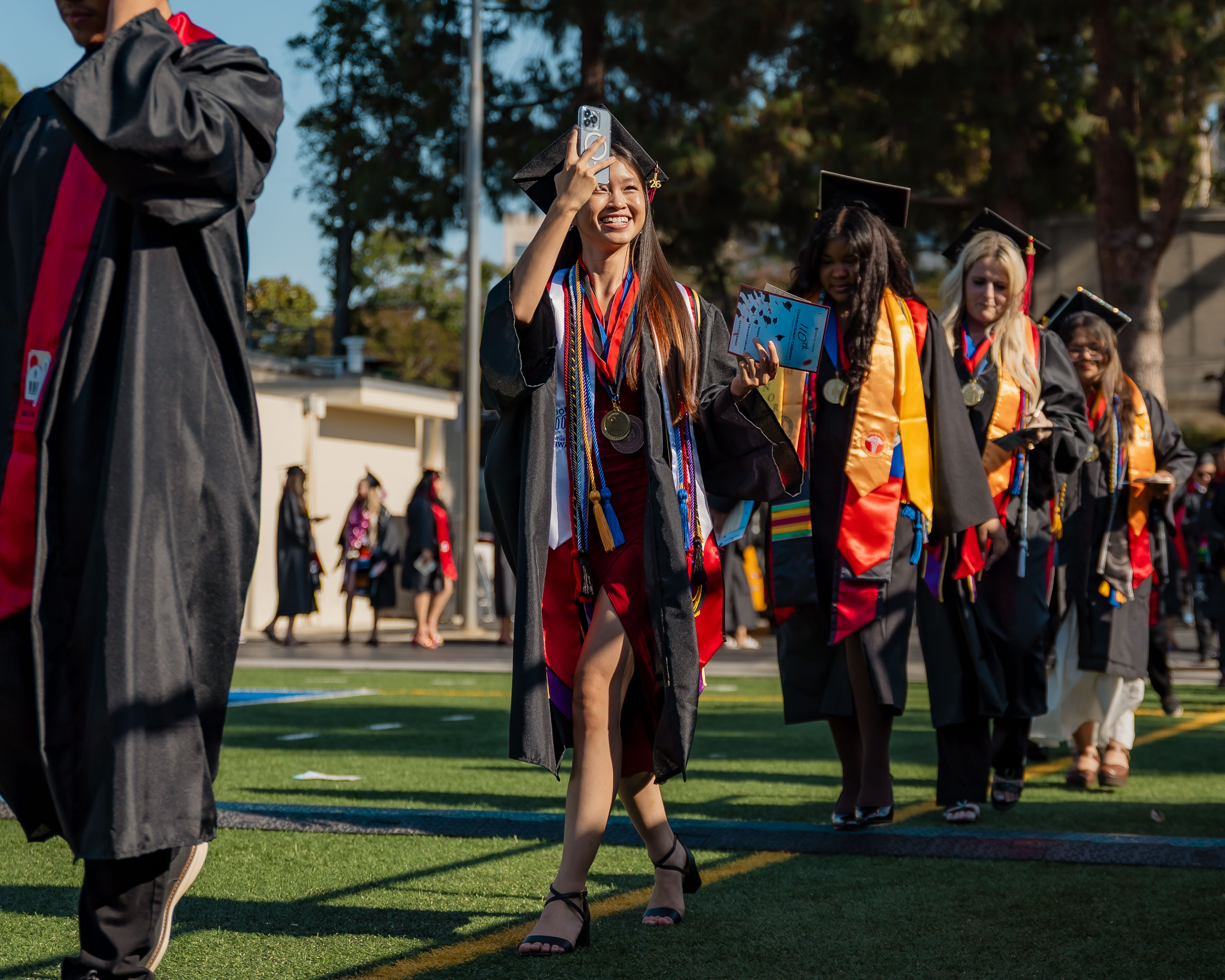 graduate taking a video while processing in 